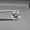 A 3.58-carat natural Shigar Valley Aquamarine (Beruj) gemstone with an octagon emerald cut, displaying a clear sea-blue hue and unique organic inclusions, held in jeweler's tweezers.