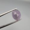 ​A 6.89-carat natural Brazilian Amethyst (Katela) gemstone with a professional oval faceted cut, displaying a deep purple hue and high transparency, held in jeweler's tweezers.