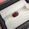 A 2.35-carat natural oval-cut Madagascar Garnet with a deep crimson red hue and high-luster facets, presented in a black jewelry box.