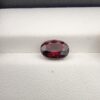 A 2.69-carat natural oval-cut Madagascar Garnet featuring a saturated deep red color and natural internal inclusions, displayed in a clear jeweler's case.