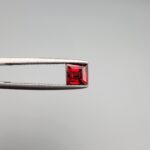 A 1.33-carat natural deep red Madagascar Garnet in a square princess or step cut, showcasing exceptional brilliance and "super sparkling" facets in a clear gemstone display.