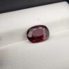 A 3.26-carat natural oval-cut Madagascar Garnet featuring a rich deep red color and high-clarity facets, displayed in a gemstone case.