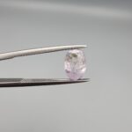 A 2.38-carat natural Ceylon purple sapphire with unique internal mountain-desert inclusions and an oval faceted cut, displayed in a white jeweler's box.