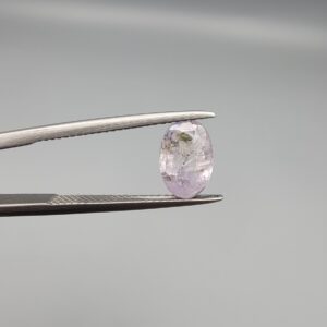 A 2.38-carat natural Ceylon purple sapphire with unique internal mountain-desert inclusions and an oval faceted cut, displayed in a white jeweler's box.