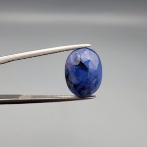​A massive 7.54-carat natural Ceylon blue sapphire with a deep royal blue color and oval faceted cut, shown in a professional jeweler's display box.