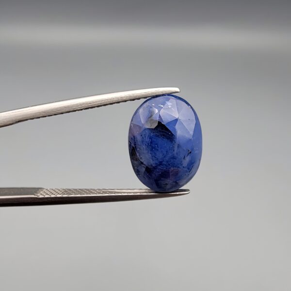 ​A massive 7.54-carat natural Ceylon blue sapphire with a deep royal blue color and oval faceted cut, shown in a professional jeweler's display box.
