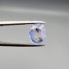 A 2.17-carat natural Ceylon blue sapphire with unique internal black and yellow inclusions, featuring an oval faceted cut and transparent blue body.