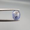 A 2.17-carat natural Ceylon blue sapphire with unique internal black and yellow inclusions, featuring an oval faceted cut and transparent blue body.