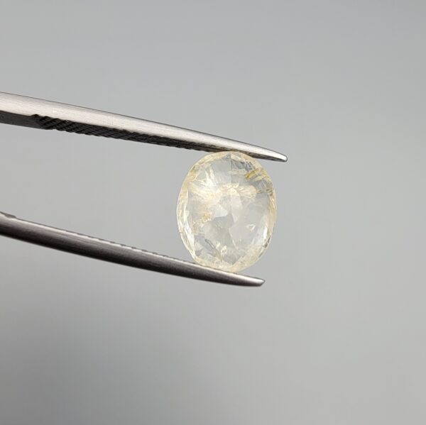 A 3.05-carat natural Ceylon yellow sapphire with transparent clarity and golden internal inclusions, featuring an oval faceted cut, displayed in a white jeweler's box.