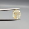 ​A 4.39-carat natural Ceylon yellow sapphire with transparent clarity and golden internal inclusions, featuring an oval faceted cut, displayed in a white jeweler's box.