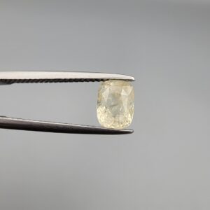 ​A 1.68-carat natural yellow sapphire from Sri Lanka (Ceylon) with a cushion faceted cut, displaying a bright canary yellow color and high transparency, presented in a white jeweler's box.