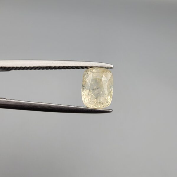 ​A 1.68-carat natural yellow sapphire from Sri Lanka (Ceylon) with a cushion faceted cut, displaying a bright canary yellow color and high transparency, presented in a white jeweler's box.
