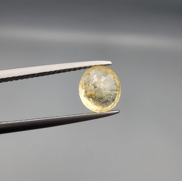 ​A 1.84-carat natural Ceylon yellow sapphire with an oval faceted cut and high transparency, displayed in a white jeweler's box.
