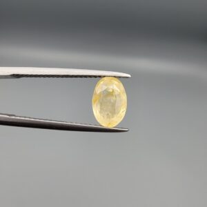 A 2.27-carat natural Ceylon yellow sapphire with an oval faceted cut and high transparency, professionally displayed in a jeweler's box.