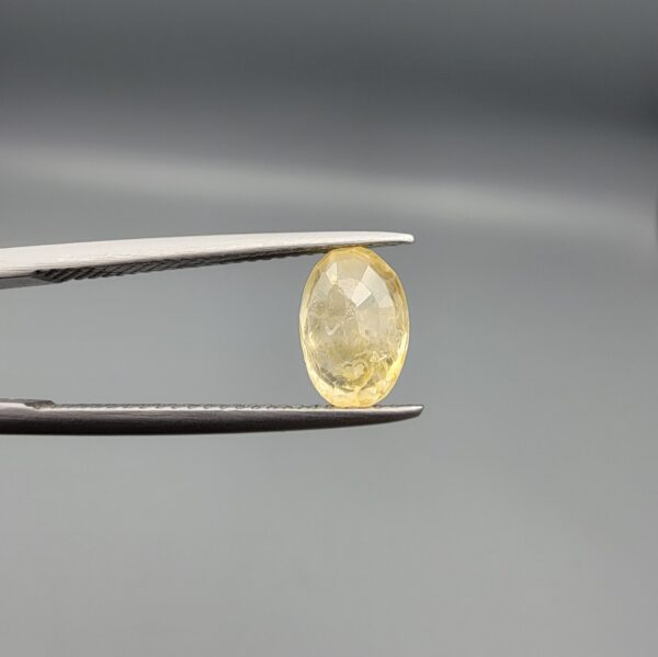A 2.27-carat natural Ceylon yellow sapphire with an oval faceted cut and high transparency, professionally displayed in a jeweler's box.