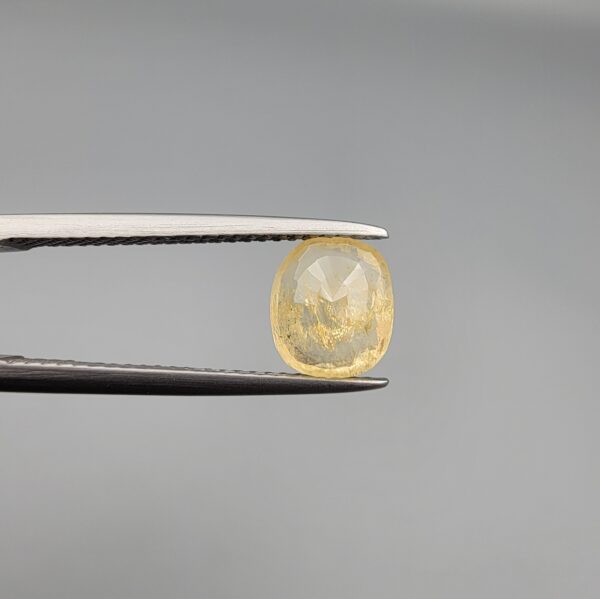 ​A 2-carat natural Ceylon yellow sapphire featuring a cushion faceted cut and high transparency, presented in a white jeweler's box.