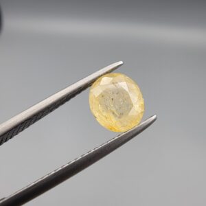 ​A 1.84-carat natural Ceylon yellow sapphire featuring an oval faceted cut and exceptional transparency, professionally displayed in a white jeweler's box.