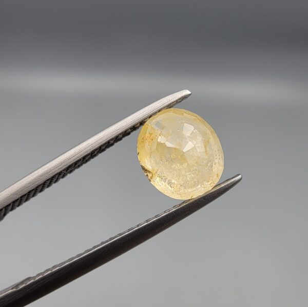​A 1.84-carat natural Ceylon yellow sapphire featuring an oval faceted cut and exceptional transparency, professionally displayed in a white jeweler's box.