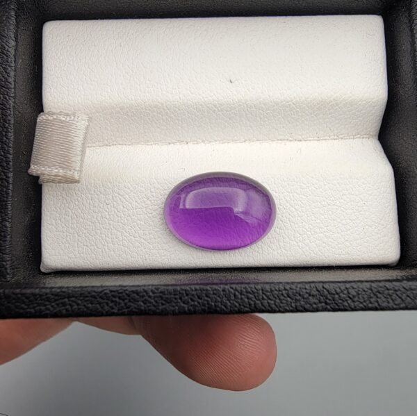 ​A 5.07-carat natural Brazilian amethyst with a rich purple color and faceted cut, accompanied by a GGI Laboratory certificate of authenticity.