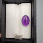 ​A 5.07-carat natural Brazilian amethyst with a rich purple color and faceted cut, accompanied by a GGI Laboratory certificate of authenticity.