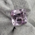 ​A massive 24-carat natural Brazilian amethyst with a light purple lavender color and faceted cut, professionally displayed in a jeweler's box.