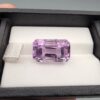 A massive 15.18-carat natural Brazilian amethyst with a soft light purple lavender color and precision faceted cut, displayed in a white jeweler's box.