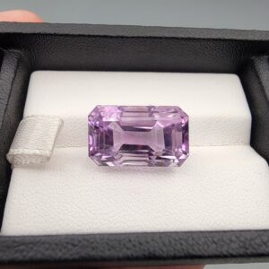 A massive 15.18-carat natural Brazilian amethyst with a soft light purple lavender color and precision faceted cut, displayed in a white jeweler's box.