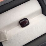 A 3.26-carat natural red garnet from Madagascar with a vibrant reddish hue and precision faceted cut, displayed in a professional jeweler's box.