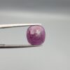 A large 6.83-carat natural Madagascar ruby with a purplish-red color, featuring visible natural mountain marks and cracks on the surface and back, displayed in a jeweler's box.