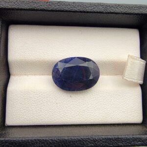 A massive 11.25-carat natural blue sapphire from Afghanistan with an oval faceted cut and deep blue color, professionally displayed in a white jeweler's box.