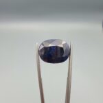 A massive 16.66-carat natural blue sapphire from Afghanistan with an oval faceted cut and deep royal blue color, professionally displayed in a white jeweler's box.