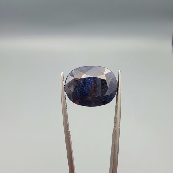 A massive 16.66-carat natural blue sapphire from Afghanistan with an oval faceted cut and deep royal blue color, professionally displayed in a white jeweler's box.