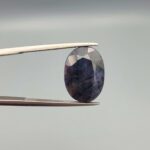An 8.45-carat natural blue sapphire from Afghanistan with an oval faceted cut and deep royal blue color, professionally displayed in a white jeweler's box.