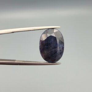 An 8.45-carat natural blue sapphire from Afghanistan with an oval faceted cut and deep royal blue color, professionally displayed in a white jeweler's box.