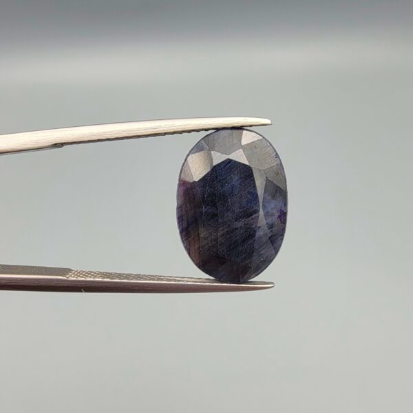 An 8.45-carat natural blue sapphire from Afghanistan with an oval faceted cut and deep royal blue color, professionally displayed in a white jeweler's box.