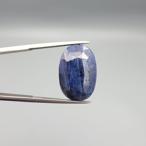 An extraordinary 25.07-carat natural blue sapphire from Afghanistan, featuring an oval faceted cut and deep blue saturation, displayed in a professional jeweler's box.
