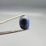 A 9.09-carat natural blue sapphire from Afghanistan with a classic oval faceted cut and rich royal blue color, professionally displayed in a white jeweler's box.
