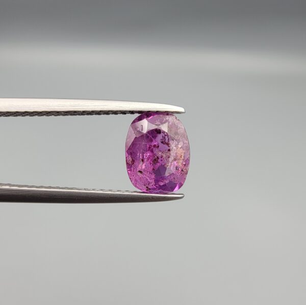 A rare 1.85-carat unheated natural purple sapphire (Khooni Neelam) from Ceylon, Sri Lanka, featuring a masterfully faceted oval cut and deep violet-purple saturation, presented in a professional white jeweler's box.