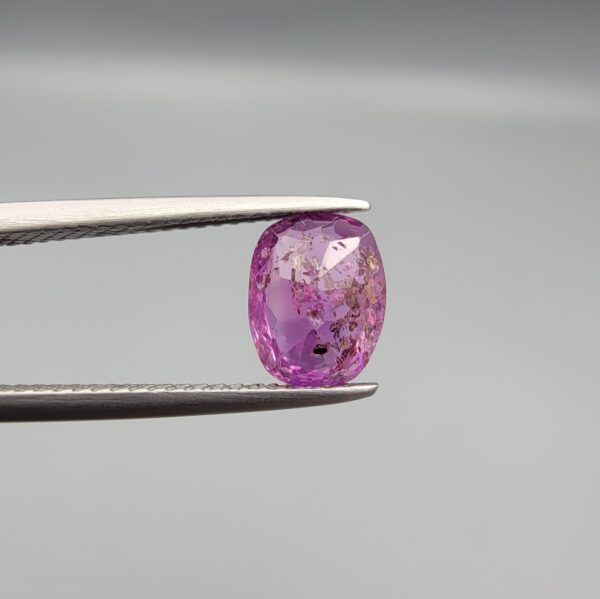 A rare 1.85-carat unheated natural purple sapphire (Khooni Neelam) from Ceylon, Sri Lanka, featuring a masterfully faceted oval cut and deep violet-purple saturation, presented in a professional white jeweler's box.
