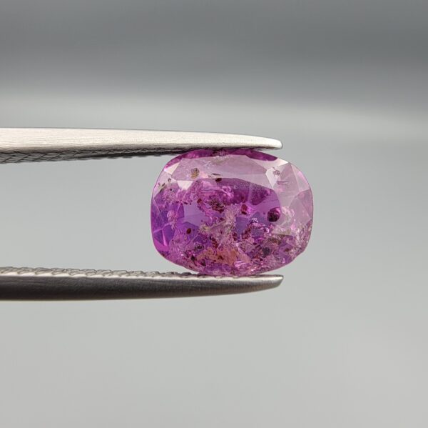 A rare 1.85-carat unheated natural purple sapphire (Khooni Neelam) from Ceylon, Sri Lanka, featuring a masterfully faceted oval cut and deep violet-purple saturation, presented in a professional white jeweler's box.