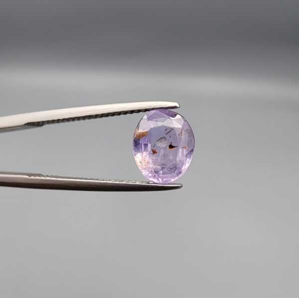 A rare 1.98-carat unheated natural purple sapphire (Khooni Neelam) from Ceylon, Sri Lanka, featuring a masterfully faceted oval cut and deep royal violet saturation, presented in a professional white jeweler's box.