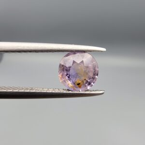 A rare 1.25-carat unheated natural purple sapphire (Khooni Neelam) from Ceylon, Sri Lanka, featuring a masterfully faceted round brilliant cut and deep royal violet saturation, presented in a professional jeweler's box.