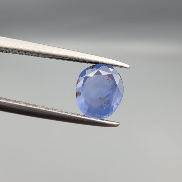 A rare 1.45-carat unheated natural blue sapphire (Neelam) from Ceylon, Sri Lanka, featuring a masterfully faceted oval cut and vivid royal blue color, presented in a professional white jeweler's box.