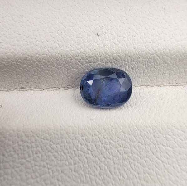 A rare 1.48-carat unheated natural blue sapphire (Neelam) from Ceylon, Sri Lanka, featuring a masterfully faceted oval cut and vivid royal blue color, presented in a professional white jeweler's box.