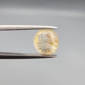 A rare 2.44-carat unheated natural yellow sapphire (Pukhraj) from Ceylon, Sri Lanka, featuring a masterfully faceted oval cut and deep golden-yellow saturation, held in professional jeweler's tweezers.