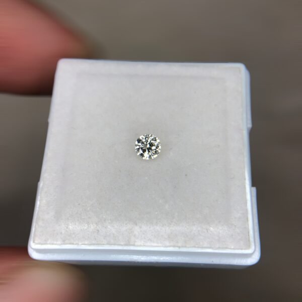 A single, brilliant-cut 0.17 carat natural white diamond (Heera) centered on a soft white background, displaying sharp internal faceting and high luster.