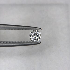 A 0.23-carat natural white diamond (Heera) with a brilliant cushion shape cut, displaying high fire and sparkle under professional lighting, held in jeweler's tweezers.