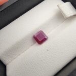 A 1.41-carat natural red ruby from Mozambique with an octagon emerald cut, showcasing high clarity and vibrant red brilliance, displayed in a professional jeweler's box.