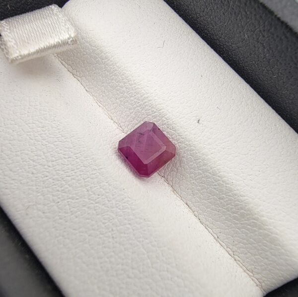 A 1.41-carat natural red ruby from Mozambique with an octagon emerald cut, showcasing high clarity and vibrant red brilliance, displayed in a professional jeweler's box.
