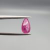 A 1.14-carat natural red ruby from Mozambique in a pear faceted cut, showing authentic natural surface pits and rich red color, displayed in a professional jeweler's box.